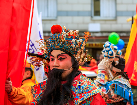 Paris, France-February 25,2018: Environmental portrait of a man disguised as a traditional character in a float during the 2018 Chinese New year parade in Paris.