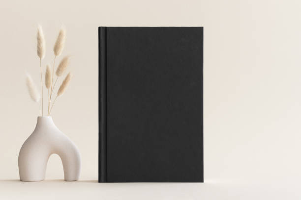 istock Black book mockup with a lagurus decoration on the soft yellow background. 1482200712