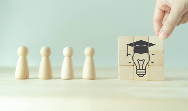istock Graduation from university, education, diploma concept. Commencement, Graduation day. Personal competency development. Wooden cubes with graduation cap on beautiful grey background and copy space. 1482200801