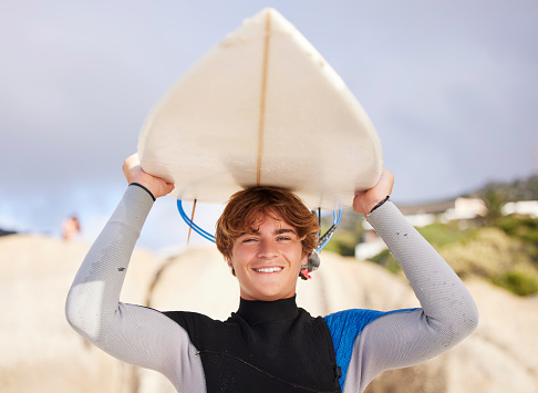 Beach, surfing and portrait of a man with a board for start of summer, fitness and relaxation. Exercise, smile and young surfer ready for training at the sea in the ocean on a holiday in Thailand