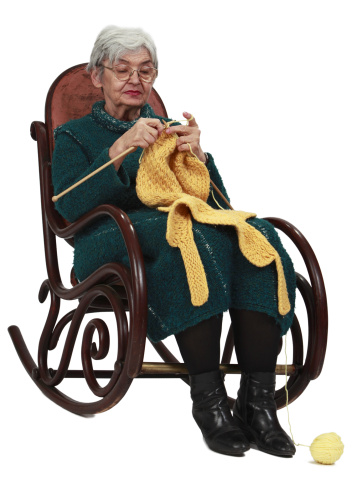 Image of an old woman sitting on a rocker and knitting, isolated against a white background.