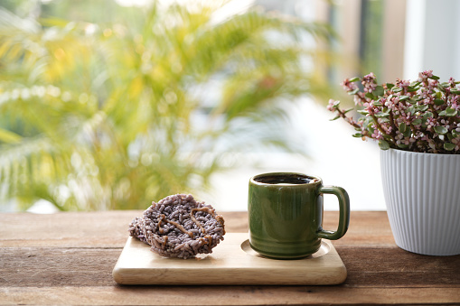 Green coffee cup and Rice crackers on wooden table