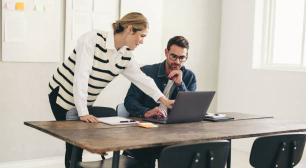 istock Two business colleagues working with a laptop in an office 1482213172