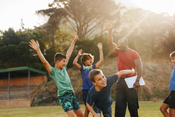 istock Elementary school kids celebrating with their sports coach 1482213248