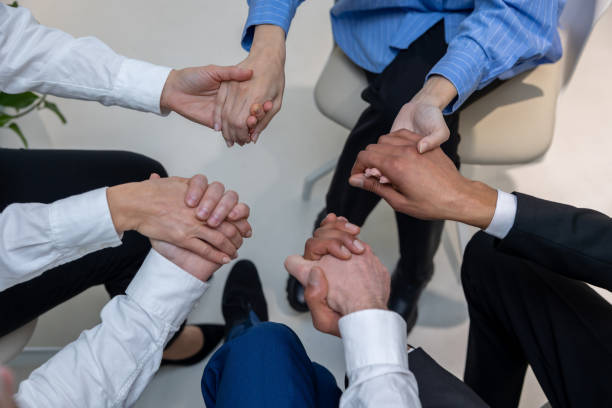 istock Close up of people holding hands during therapy session 1482220974