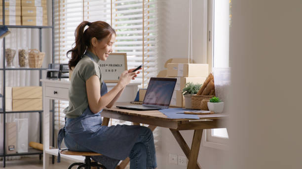 Go green SME owner reply chat comment online talk or set up chatbot on phone. Young seller asia woman typing mobile at home office easy selling CRM platform for eco friendly shop retail net zero store vaya verde propietario de una pyme responda chat comentario conversación en línea o configure chatbot en el teléfono. joven vendedor asia mujer escribiendo móvil en casa oficina fácil venta plataforma crm para tienda ecológica tienda minorista neta c