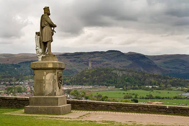 Statue of King Robert the Bruce found at Stirling Castle. Wallace Monument and the Ochil Hills in the distance.