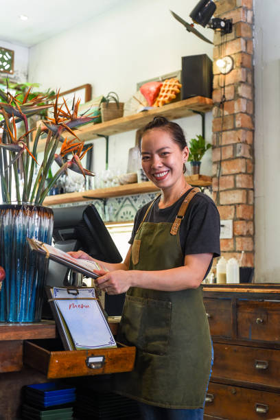 Vietnamese happy waitress working in a kitchen of a cafe stock photo
