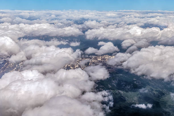 view from the stratosphere to a cloudy landscape over mountains covered with snow in summer - earth stratosphere space planet imagens e fotografias de stock