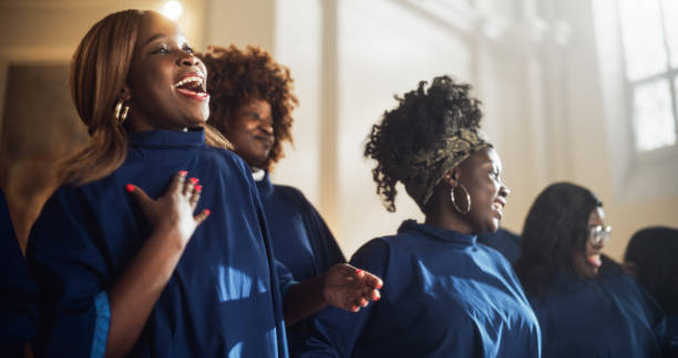 schwarze christliche gospelsänger in der kirche klatschen und stampfen und preisen herrn jesus christus. gesang verbreitet harmonie freude und glauben. energiegeladener chor, der die botschaft des christentums mit erhebender musik teilt - evangelium stock-fotos und bilder