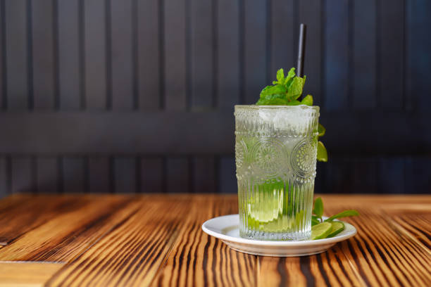 istock Alcohol cocktail Mojito on wooden table against dark wall with copy space 1482226550