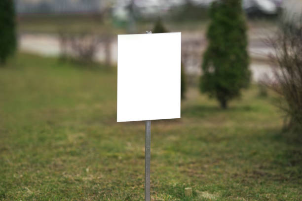 istock White empty sign with mockup space located on lawn with green grass 1482227795