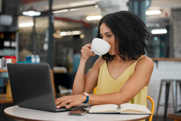 istock Coffee, internet cafe and laptop with a black woman blogger doing research while doing remote work. Restaurant, freelance and startup with a female entrepreneur working on her small business blog 1482228484