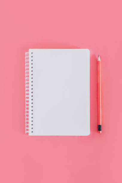 istock Notebook with a blank page and a pencil on pink background. 1482229714