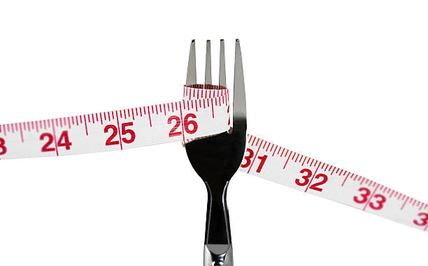 Measuring tape wrapped around fork stock photo