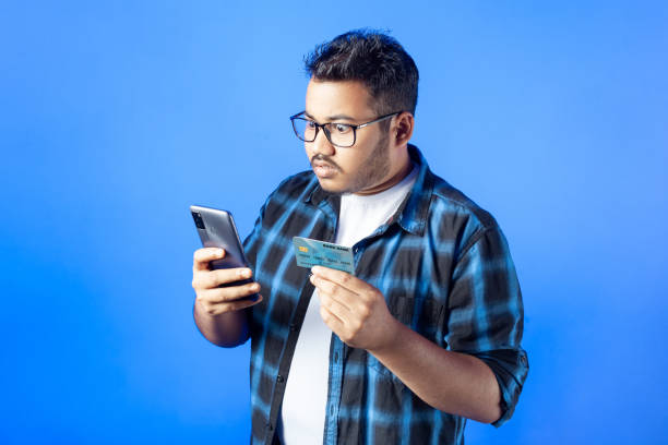 istock A surprised college student reading text message on his cell phone with credit card on his hand 1482231187
