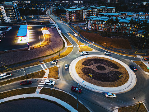 Aerial view of a residential/retail landscape with a roundabout at dusk.