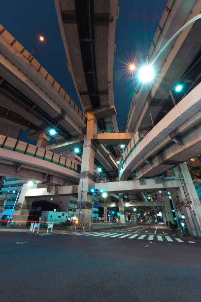 Elevated highways illuminated at night soaring over streets Tokyo Japan Looking up at the elevated night view of Hakozaki Junction from the bottom low angle street japan stock pictures, royalty-free photos & images