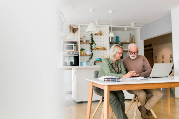 istock Senior couple using laptop while planning their home budget, 1482240729