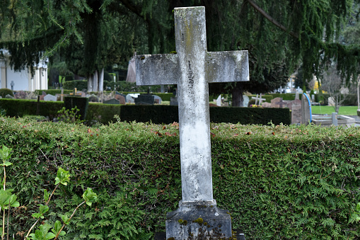 a cross in the middle of the cemetery around the church area.