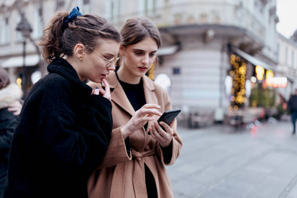 istock Two friends using smartphones to see in which direction to go 1482250297