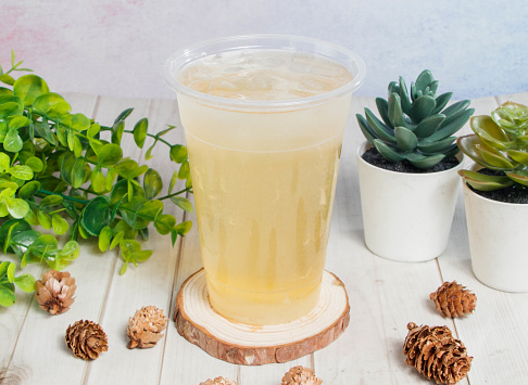 lemon and honey ice tea served on disposable glass isolated on wooden board top view of hong kong drink