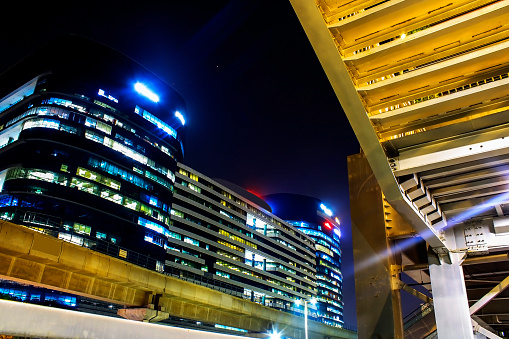 Modern building illuminated at night in Cyber city, Gurgaon, India. Low angle view