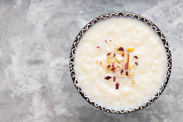 istock Bowl with rice pudding on a gray background. Rice kheer with cashew nuts and almonds on concrete. Copy space. Top view 1482255284