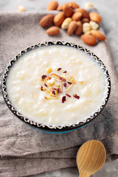 istock Indian rice kheer with nuts on a gray background. Bowl with rice pudding and a linen napkin on concrete. Top view 1482256152