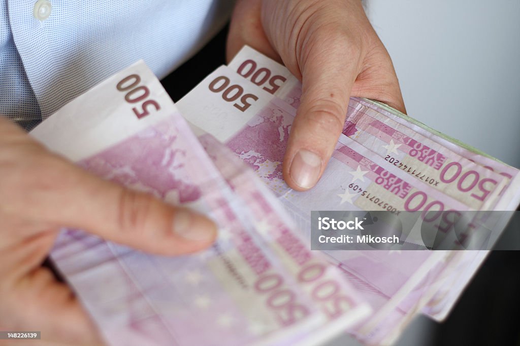 Counting Big Euros A man is counting fivehundred Euro banknotes Abundance Stock Photo
