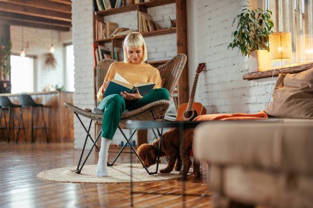 istock Young woman reading book at home. 1482261758