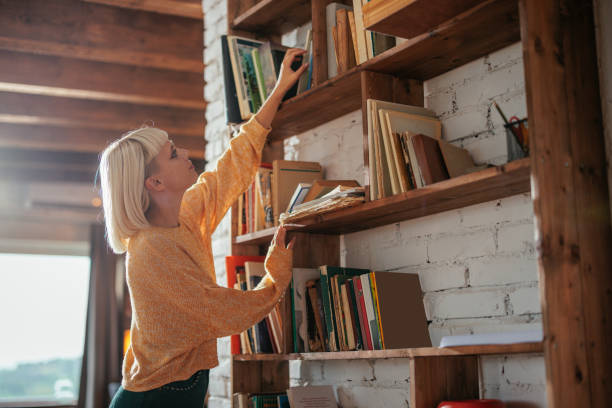 istock Young woman taking book from bookshelf. 1482261916