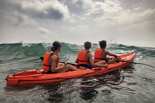 Three teenagers enjoying kayaking in the sea on sunny summer day.
Canon R5