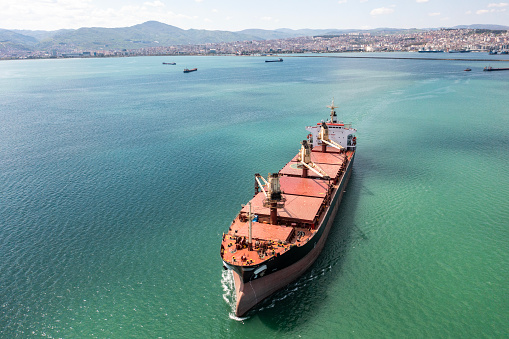 Aerial view of Container freight ship carrying container box for import and export business logistic and transportation by container ship in open sea. Approaching to Samsun international port.