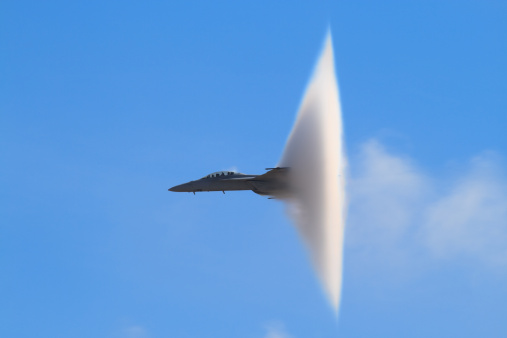 A distinctive vapor cone forms around the jet as it nears the speed of sound, otherwise known as the Prandtl-Glauert Singularity.