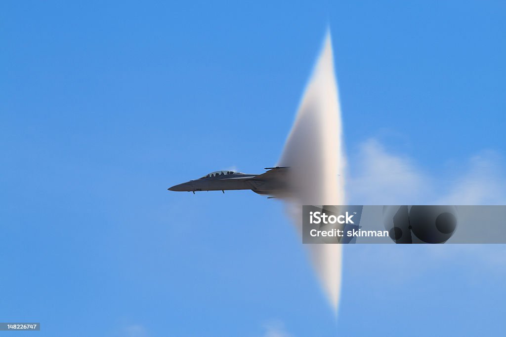 F-18 Super Hornet Vapor Cone A distinctive vapor cone forms around the jet as it nears the speed of sound, otherwise known as the Prandtl-Glauert Singularity. Supersonic Airplane Stock Photo