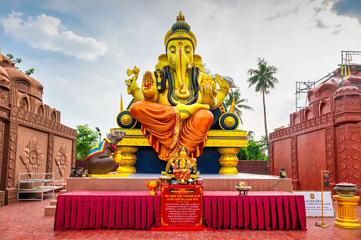 Giant statue of Ganesha at Maha Devalaya Hindu Temple in Bang Kachao, Bangkok, Thailand on a cloudy day.