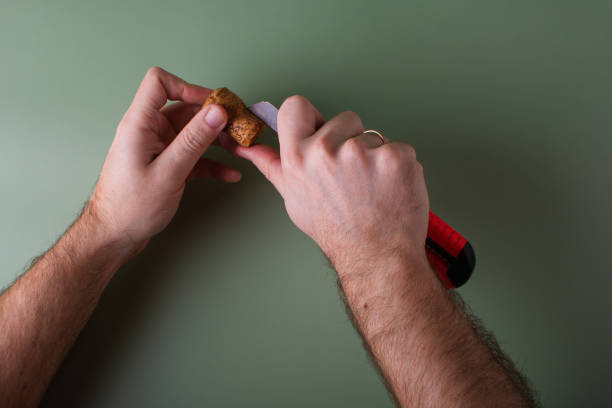 A man's hand holds cut corks and cuts them. Preservation of the planet's ecology. Raw materials for reuse. Environmental protection.