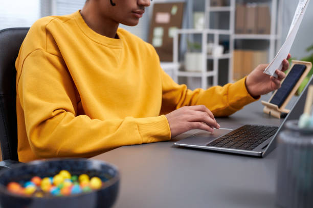 istock Closeup of young black man working or studying at home office workplace 1482270104
