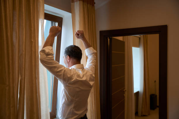 istock Man looking out the window in the hotel 1482270966