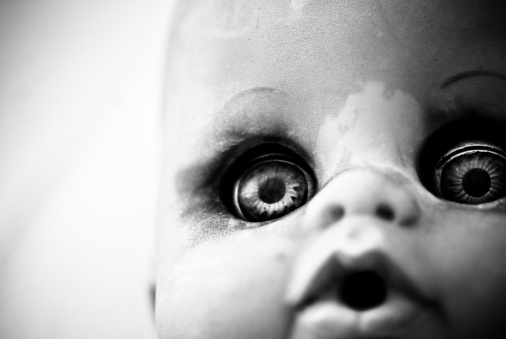 Close up of a scary dirty doll in black and white