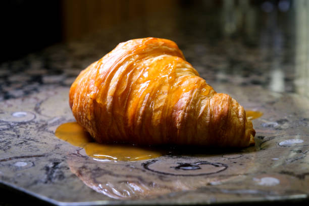 istock Delicious croissant and caramel on white plate 1482275205