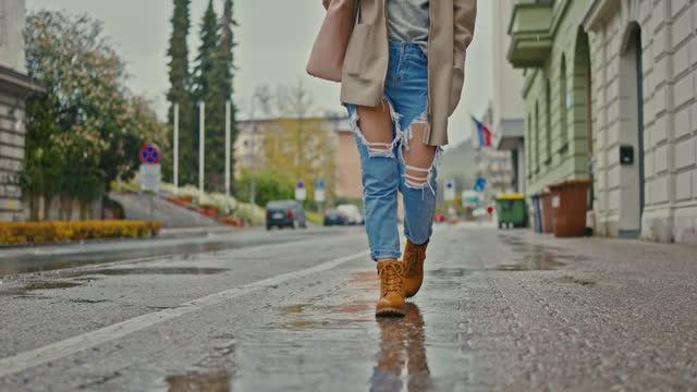 SLO MO Unrecognizable Woman walking around the city on a rainy day