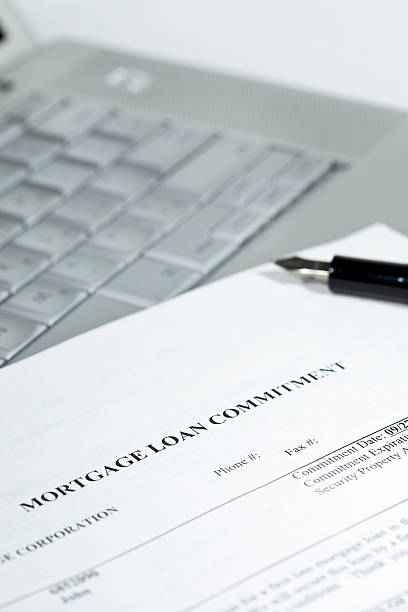 istock Mortgage contract and pen sitting on a laptop 148228368