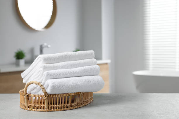 istock Wicker basket with white towels on table in bathroom. Space for text 1482285943