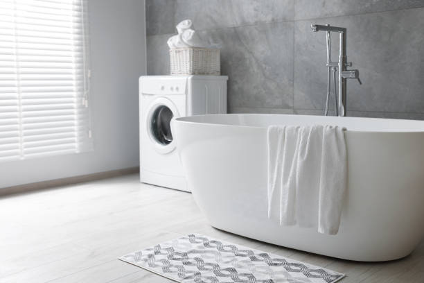 istock Fresh white towels on tub in bathroom. Space for text 1482285944