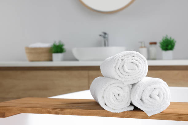 istock Rolled white towels on tub in bathroom. Space for text 1482285948