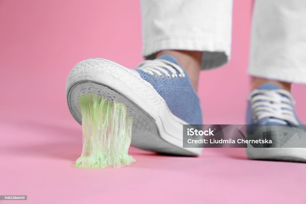Person stepping into chewing gum on pink background, closeup Bubble Gum Stock Photo