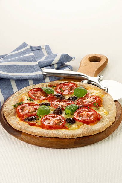 Traditional pizza on a wooden tray stock photo
