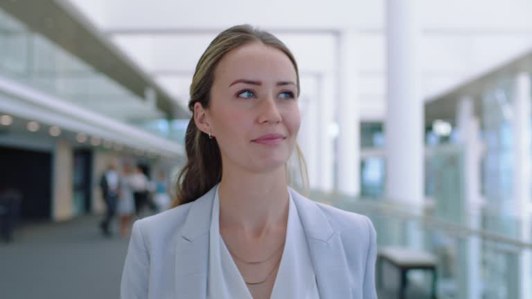 confident business woman smiling enjoying successful corporate career independent female executive walking in airport lobby wearing stylish suit with confidence 4k footage